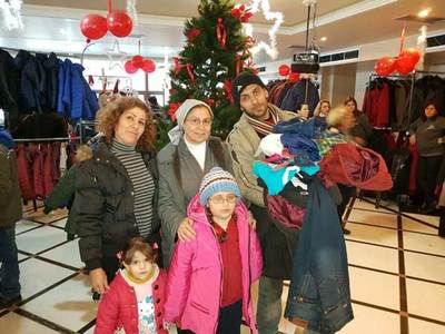 Familie aus Aleppo mit Kleidung auf dem Arm