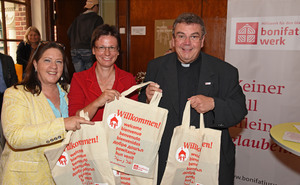 Bild: Drei Leute halten Taschen hoch